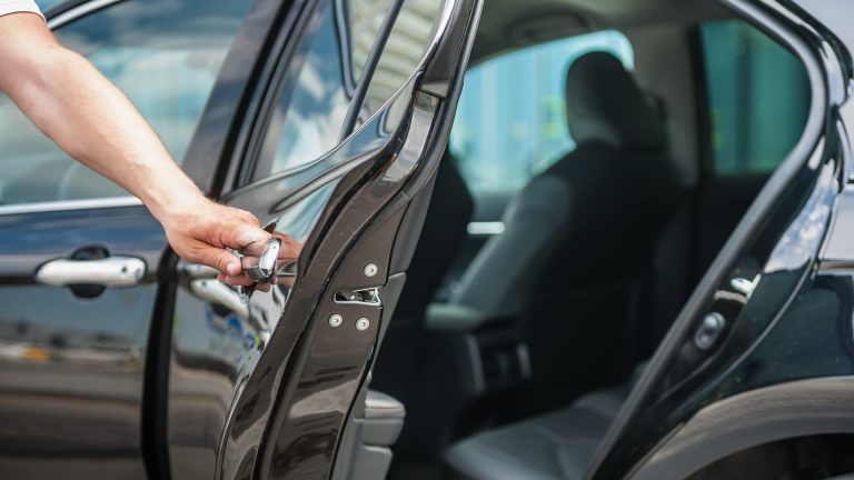 chauffeur opening black car door